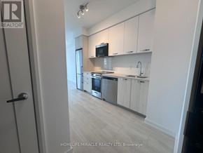 Hamilton (Corktown) condo for rent - A modern kitchen with white cabinets and stainless steel appliances.