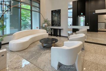 Toronto (Mount Pleasant West) condo for rent - A modern living room with a white sofa and a glass table.