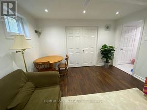 Toronto (Don Valley Village) apartment for rent - A living room with a brown couch, a round table, and a potted plant.
