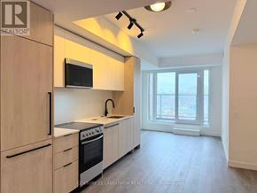 Toronto (Centennial Scarborough) condo for rent - A kitchen with wooden cabinets and a microwave above the stove.