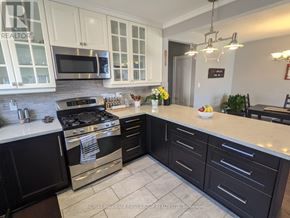 Ajax (South East) apartment for rent - A kitchen with black cabinets and a stove top oven.