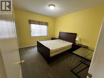 Richmond apartment for rent - A bedroom with a bed, nightstand, and window.