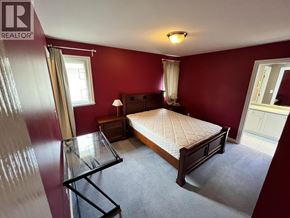 Richmond apartment for rent - A bedroom with a bed, nightstand, and window.