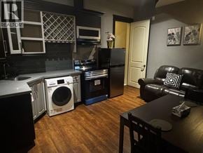 Richmond apartment for rent - A kitchen with a black fridge and a black couch.