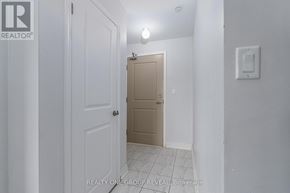 Clarington (Bowmanville) condo for rent - A hallway with a white door on the left and a beige door on the right.