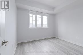 Clarington (Bowmanville) condo for rent - A white room with a window and wooden flooring.