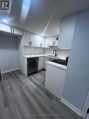 Oshawa (Taunton) apartment for rent - A kitchen with white cabinets and a dishwasher.