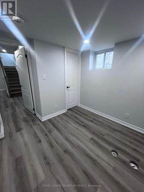 Oshawa (Taunton) apartment for rent - A room with a wooden floor and a staircase.