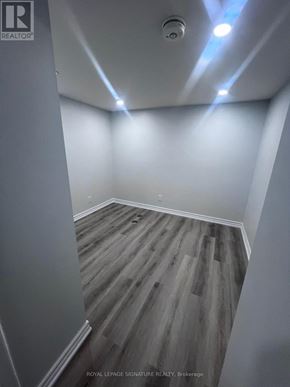 Oshawa (Taunton) apartment for rent - A room with wooden flooring and white walls.