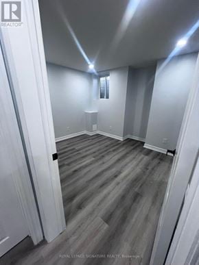 Oshawa (Taunton) apartment for rent - A room with wooden flooring and white walls.
