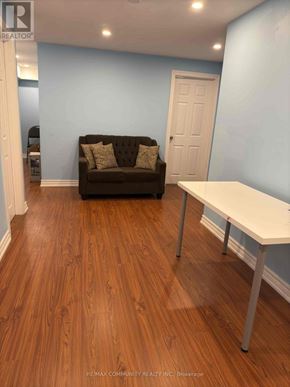 Markham (Cedarwood) apartment for rent - A brown couch sits in a room with a white table.