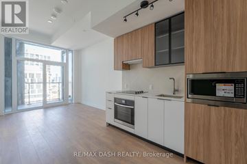 Toronto (Islington-City Centre West) condo for rent - A modern kitchen with white cabinets and a wooden countertop.