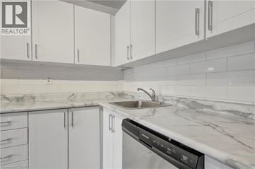 Mississauga townhouse for rent - A modern kitchen with white cabinets and a marble countertop.