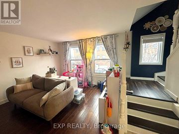 Hamilton (Randall) townhouse for rent - A living room with a couch and a staircase.