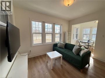 Kitchener apartment for rent - A living room with a green couch and a flat screen TV.