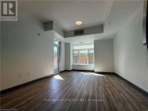 Strathroy-Caradoc (Mount Brydges) townhouse for rent - A room with wood flooring and a window overlooking a fence.