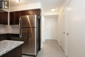 Toronto (Dovercourt-Wallace Emerson-Junction) condo for rent - A kitchen with a stainless steel refrigerator and cabinets.