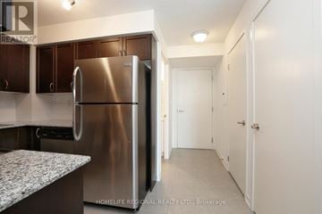 Toronto (Dovercourt-Wallace Emerson-Junction) condo for rent - A kitchen with a stainless steel refrigerator and cabinets.