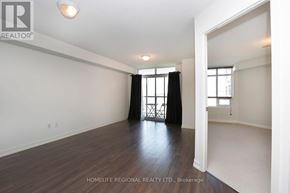 Toronto (Dovercourt-Wallace Emerson-Junction) condo for rent - A spacious room with wooden flooring and white walls, with a window and a door visible.