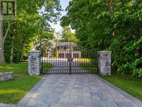 Halton Hills (Rural Halton Hills) apartment for rent - A black gate with a stone pillar on either side blocks the entrance to a driveway.