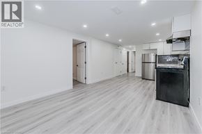 Waterloo apartment for rent - A spacious kitchen with a black fridge and wooden flooring.