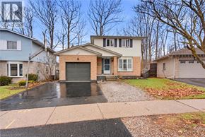 Kitchener apartment for rent - A house with a grey garage door is surrounded by other houses.