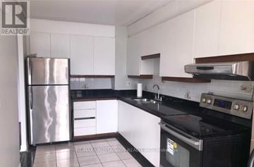 Toronto (Flemingdon Park) condo for rent - A kitchen with a stainless steel refrigerator and black countertops.