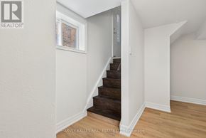 Toronto (Eringate-Centennial-West Deane) apartment for rent - A staircase in a house with a white wall and wooden steps.