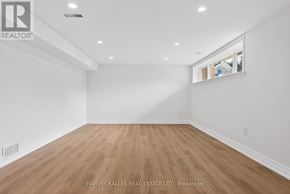 Toronto (Eringate-Centennial-West Deane) apartment for rent - A spacious room with wooden flooring and white walls.