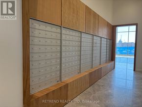 Toronto (Don Valley Village) condo for rent - A wall of mailboxes in a hallway with a view of a lake outside the window.