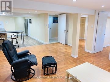 Toronto (Yonge-Eglinton) triplex for rent - A living room with a black chair and ottoman in front of a white table.