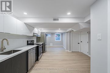 Ottawa apartment for rent - A modern kitchen with white cabinets and a wooden floor.