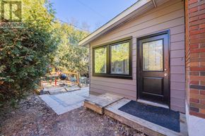 Ottawa apartment for rent - A small house with a black door and a small garden in front.