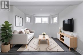 Barrie (Holly) apartment for rent - A living room with a white couch, a wooden coffee table, and a flat-screen TV mounted on the wall.
