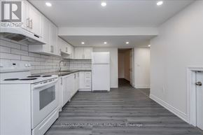 Barrie (Holly) apartment for rent - A white kitchen with a stove top oven and a refrigerator.
