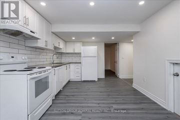Barrie (Holly) apartment for rent - A white kitchen with a stove top oven and a refrigerator.