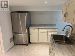 Toronto (Dovercourt-Wallace Emerson-Junction) apartment for rent - A kitchen with a stainless steel refrigerator, white cabinets, and a granite countertop.