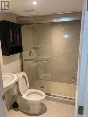 Toronto (Dovercourt-Wallace Emerson-Junction) apartment for rent - A bathroom with a toilet, a cabinet, and a walk-in shower.