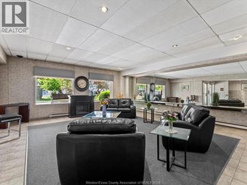Windsor condo for rent - A living room with black furniture and a large window.