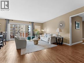 Windsor condo for rent - A well-lit living room with a white sofa and a grey armchair.
