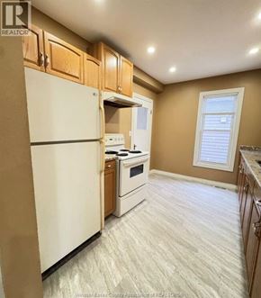 Windsor apartment for rent - A kitchen with a white refrigerator, a white stove, and wooden cabinets.