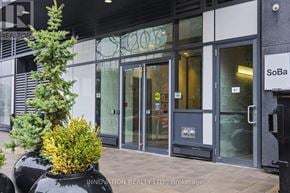 Ottawa condo for rent - The front of a building with the sign "INNOVATION REALTY LTD., Brokerage" on the planter.