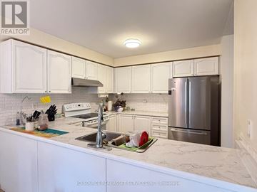 Oshawa (Windfields) apartment for rent - A kitchen with white cabinets and a marble countertop.