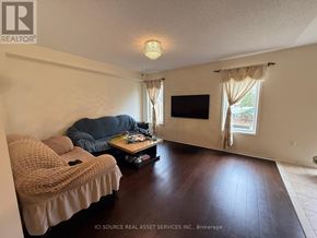 Oshawa (Windfields) apartment for rent - A living room with a couch, a coffee table, and a flat screen TV.