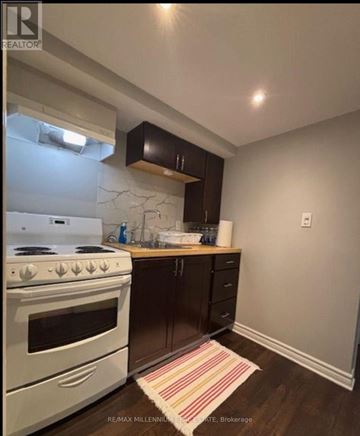 Mississauga (Erindale) apartment for rent - A kitchen with a white stove and black cabinets.