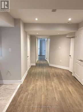 Brampton (Northwest Brampton) apartment for rent - A long, narrow hallway with wood flooring and white walls.