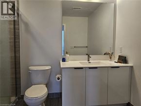 Kitchener condo for rent - A white toilet sits next to a sink in a bathroom.