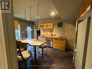 Aylmer multi-family for rent - A kitchen with a table and chairs in the middle of the room.