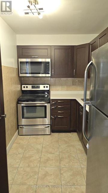 Mississauga (Hurontario) condo for rent - A kitchen with a stove top oven, microwave, and refrigerator.