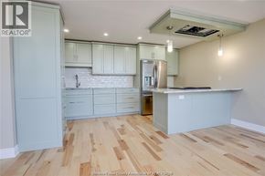 Windsor condo for rent - A kitchen with wooden floors and white cabinets.
